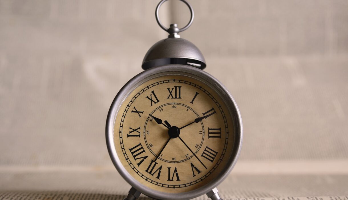 An alarm clock on a desk showing ten past ten