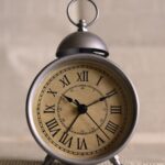 An alarm clock on a desk showing ten past ten
