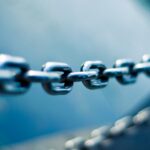 A single stainless steel chain link in shallow focus