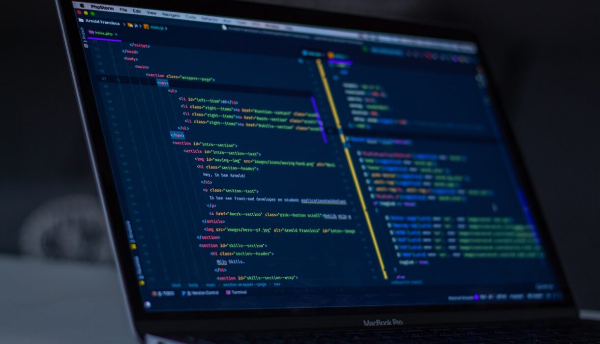 A laptop screen showing lines of running code