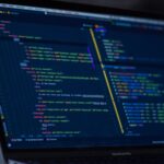A laptop screen showing lines of running code